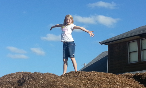 Girl standing on top of a pile of mulch